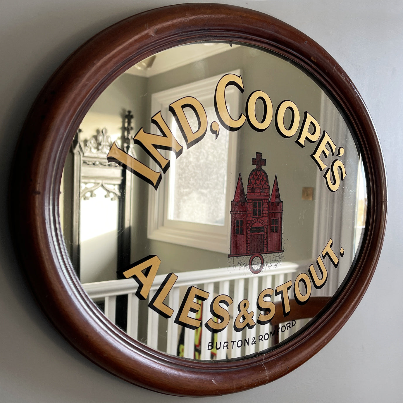 An Original Ind Coope's Pub Mirror with great foxing around the central red church. It has a rounded mahogany frame with the 'Ind Coope & Co Ltd' stamp in. A fine example of brewery advertising - SHOP NOW - www.intovintage.co.uk