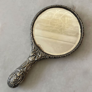 A  highly decorated antique hand mirror from the early 20th Century. The back is decorated with green men, scrolling foliage and birds. The handle sees Art Nouveau styled faces back and front - SHOP NOW - www.intovintage.co.uk