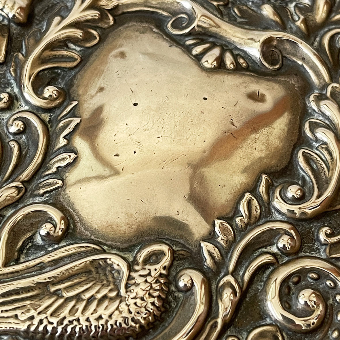 A  highly decorated antique hand mirror from the early 20th Century. The back is decorated with green men, scrolling foliage and birds. The handle sees Art Nouveau styled faces back and front - SHOP NOW - www.intovintage.co.uk