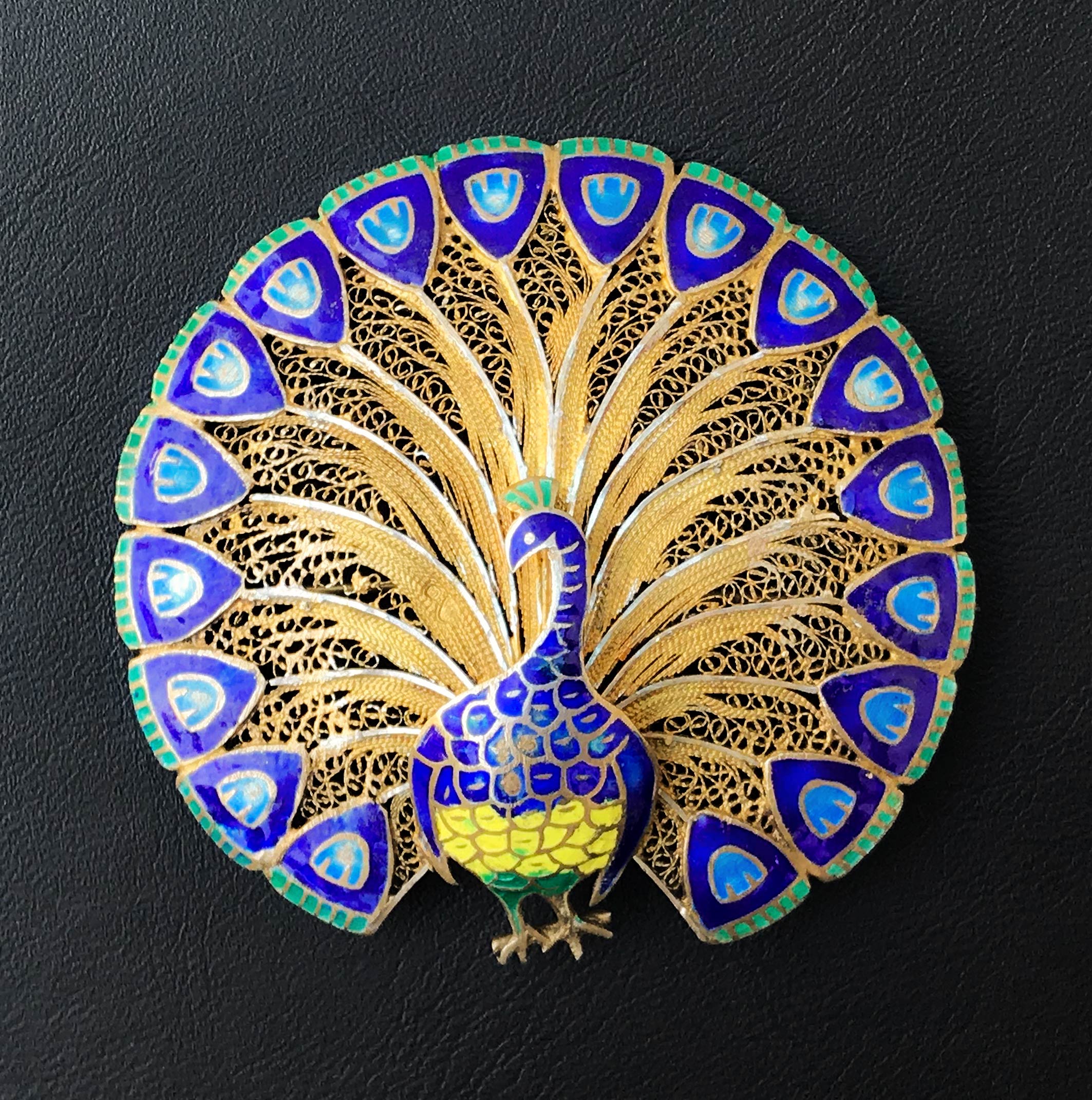 An excellent quality vintage brooch with delicate filigree detail finished in gilded silver with bright enamelled details on the peacock's body and at the end of his plumage - SHOP NOW - www.intovintage.co.uk