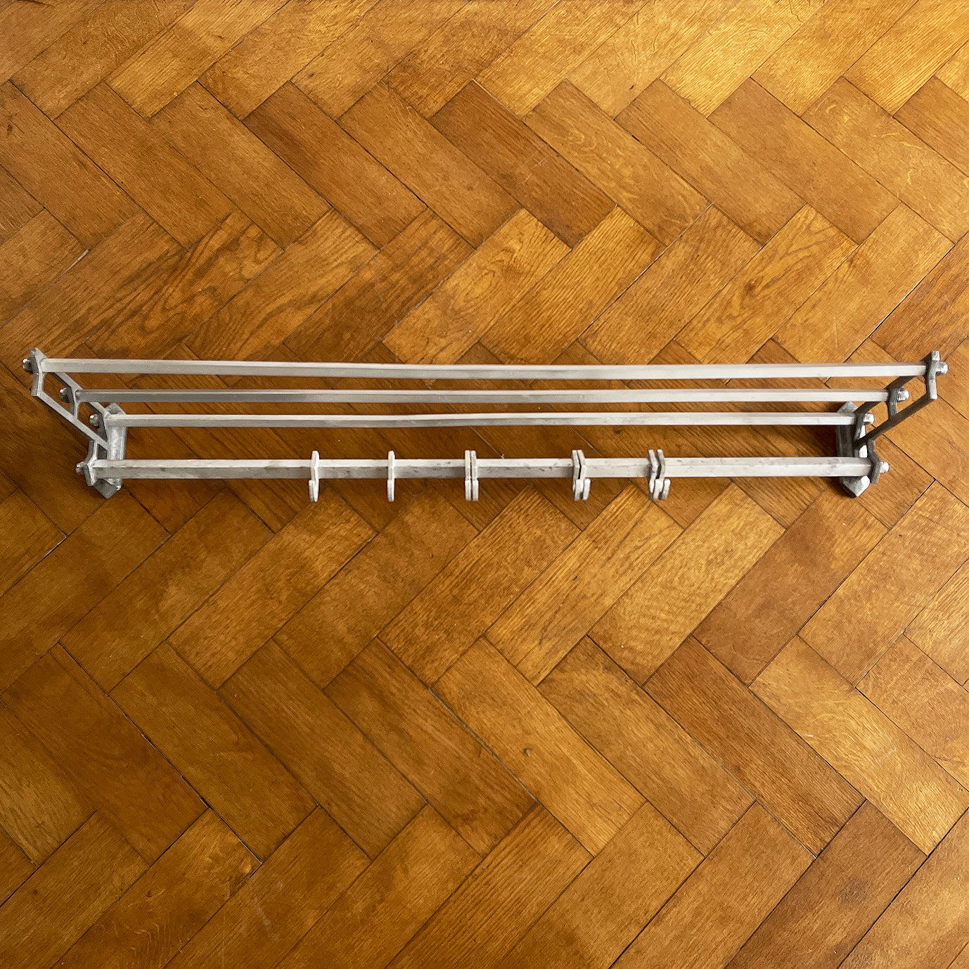 An Aluminium Art Deco Train Coat Rack, having three slats to the top section where you can place your hats and a bottom ball that has eight sliding coat hooks. The ends have a simple Art Deco styling to them - SHOP NOW - www.intovintage.co.uk