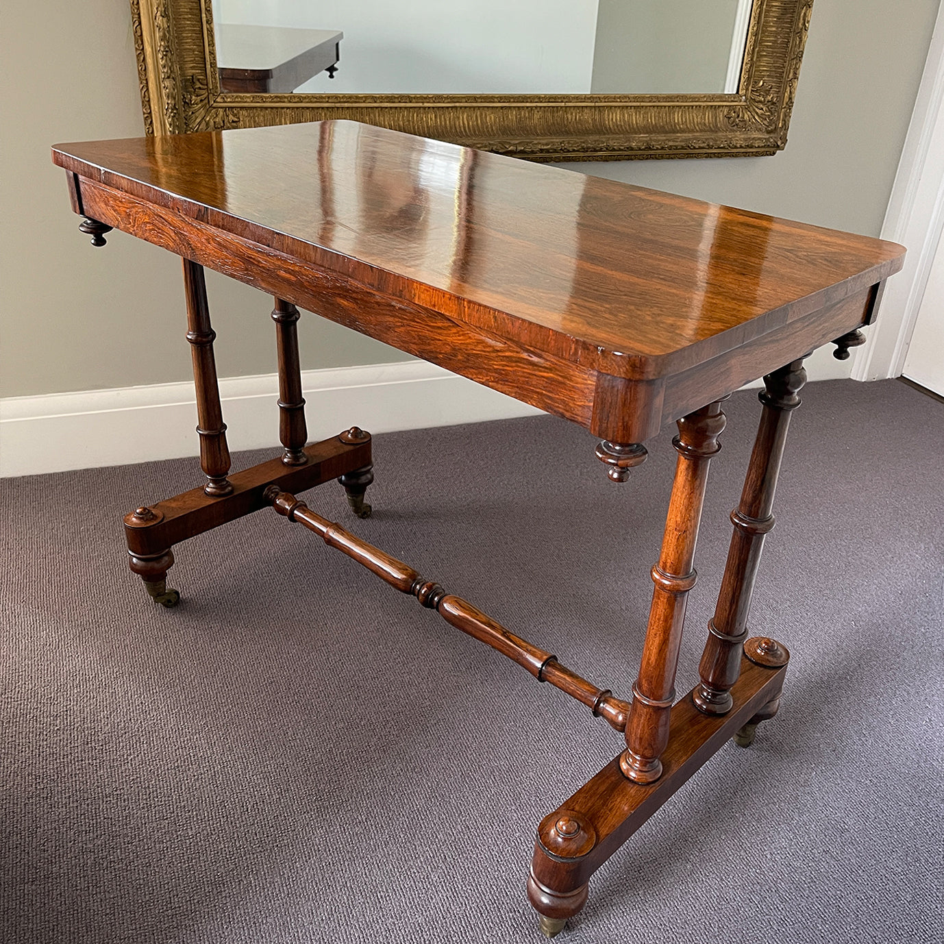A mid Victorian rosewood stretcher base table with well figured rectangular top that sits upon turned legs and stretcher, raised on original brass castors. English. Superb condition. - SHOP NOW - www.intovintage.co.uk