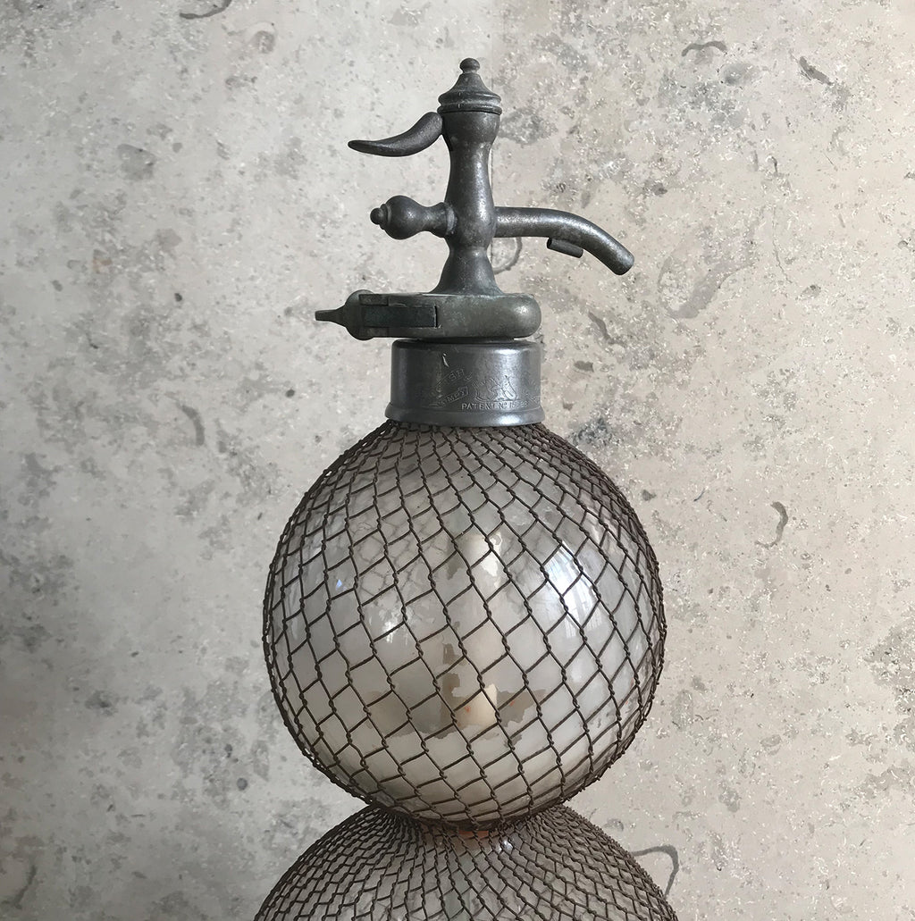 An early English soda syphon of double gourd form with a metal wire mesh net to the body, stamped 'British Syphon Company London'. Circa 1890 - SHOP NOW - www.intovintage.co.uk