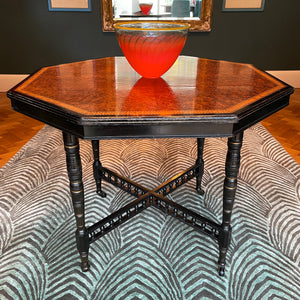 A Victorian marquetry & ebonised octagonal centre table in the Aesthetic manner by Alexander Mackenzie & Co, Glasgow.The top sees a rich burr wood veneer edged with fine blond wood marquetry, whilst underneath sees four turned ebonised legs with gold painted detailing and crossed bobbin stretchers - SHOP NOW - www.intovintage.co.uk