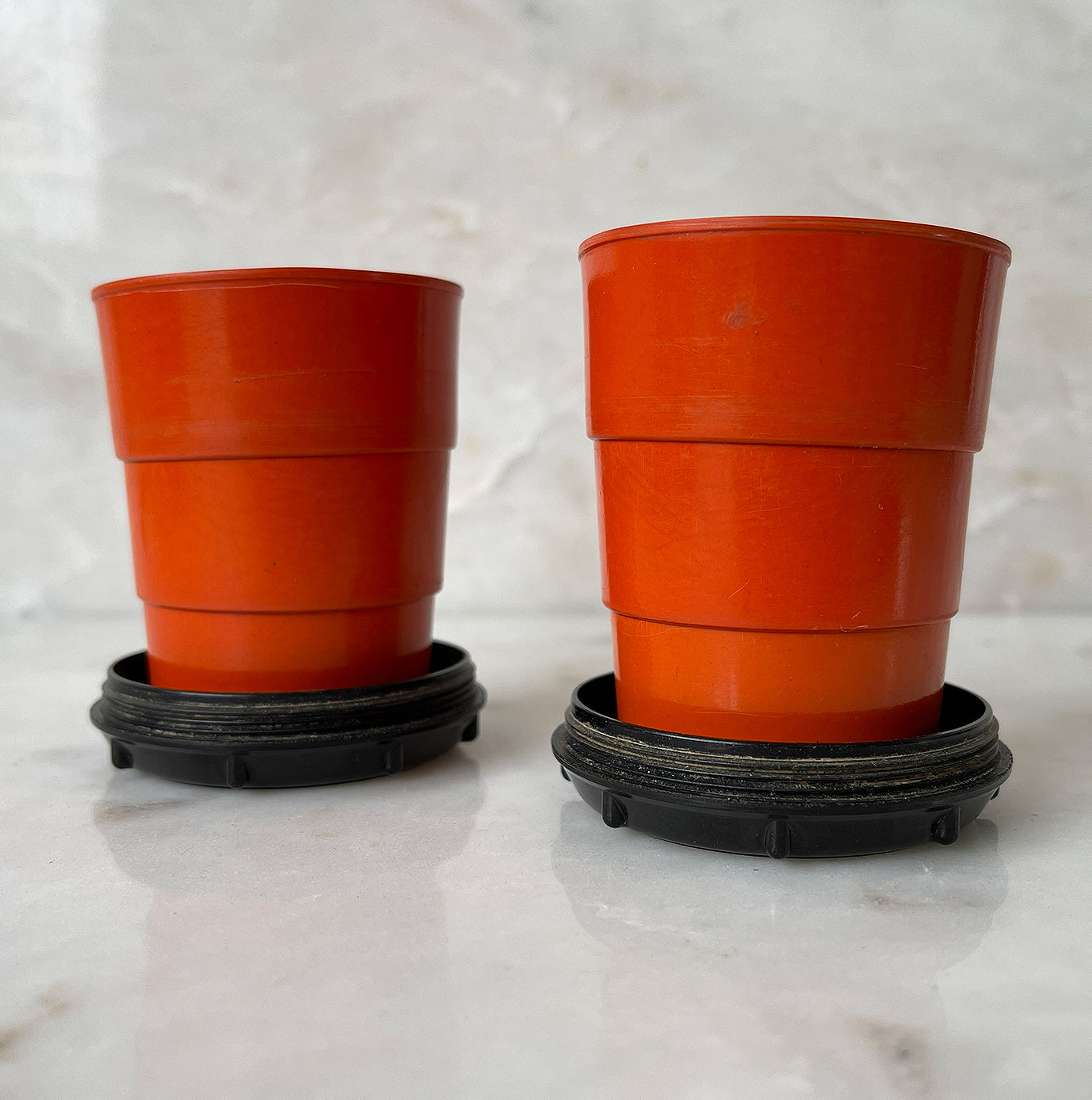 A pair of Art Deco Bakelite Telescopic Cups in a popping orange colour with black base. Unscrew the lid and pull up the rim inside to create a water tight cup! The perfect size to keep in your pocket for a little tipple if you are out and about - SHOP NOW - www.intovintage.co.uk